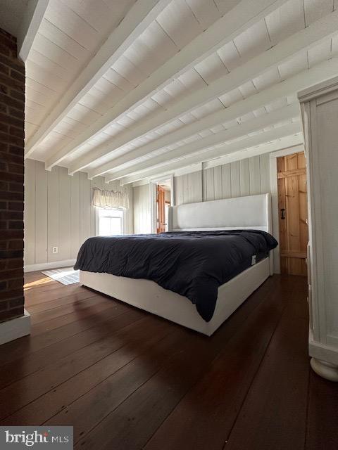 bedroom with beamed ceiling, wood-type flooring, and wooden ceiling