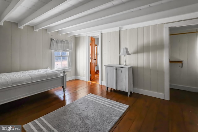 bedroom featuring wood-type flooring, beamed ceiling, and baseboards