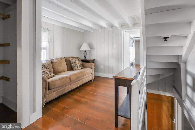 living area featuring beamed ceiling and wood finished floors