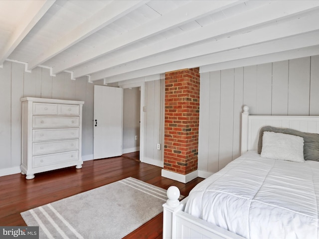 bedroom featuring wood finished floors, beam ceiling, and baseboards