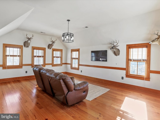 living room with vaulted ceiling, visible vents, and light wood-style flooring