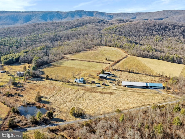 birds eye view of property featuring a rural view, a mountain view, and a view of trees