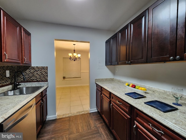 kitchen with stainless steel dishwasher, decorative light fixtures, a notable chandelier, dark tile patterned flooring, and sink