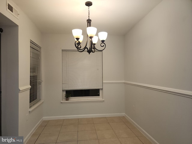 unfurnished dining area with an inviting chandelier and light tile patterned floors