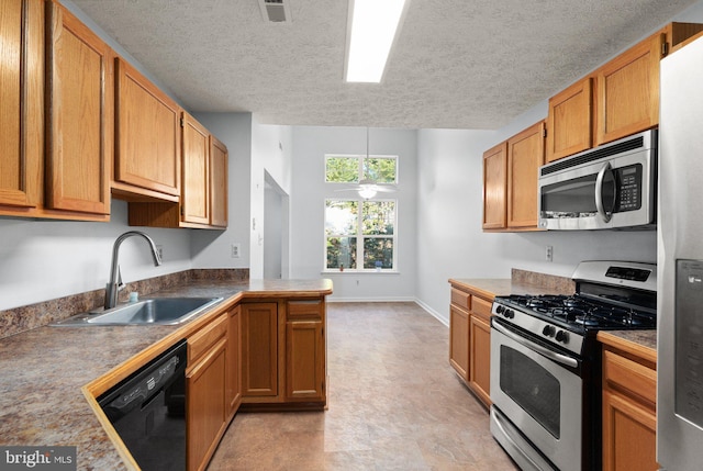 kitchen with sink, a textured ceiling, ceiling fan, and appliances with stainless steel finishes