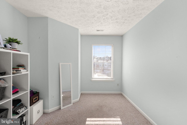 unfurnished bedroom featuring a textured ceiling and light colored carpet