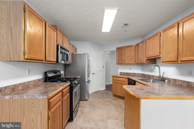 kitchen featuring a textured ceiling, stainless steel appliances, kitchen peninsula, and sink