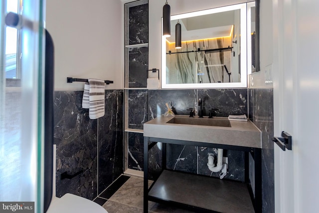 bathroom with sink and tile walls