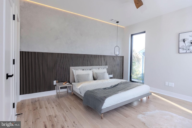 bedroom featuring multiple windows, ceiling fan, and light hardwood / wood-style flooring