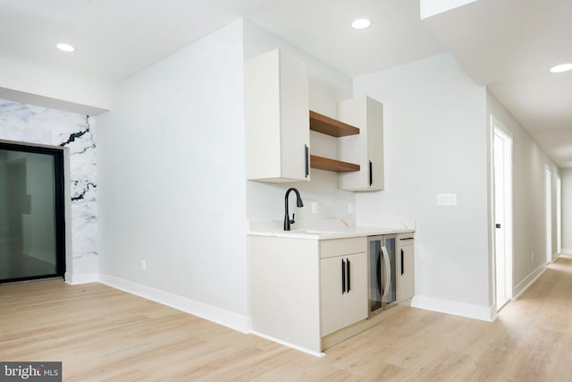 kitchen featuring sink, white cabinets, and light wood-type flooring