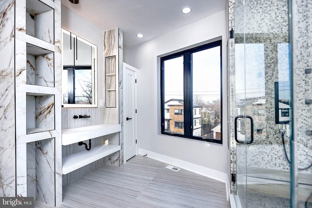 bathroom featuring a shower with door