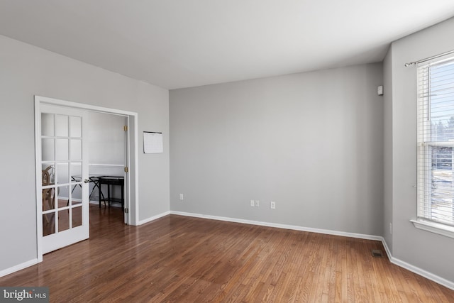 spare room with plenty of natural light and hardwood / wood-style floors