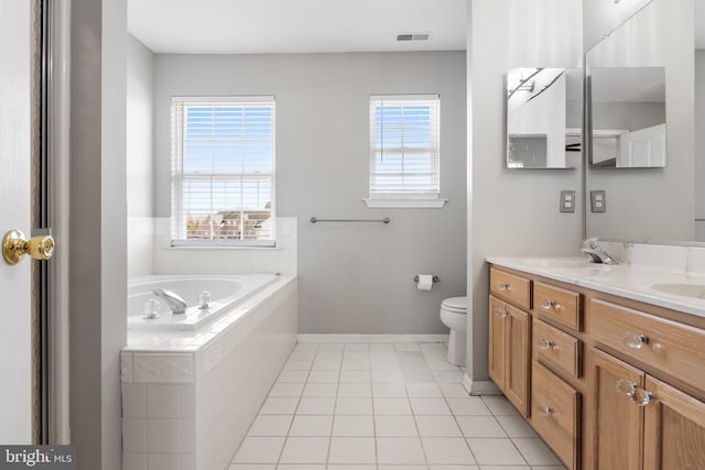 bathroom featuring vanity, tiled tub, tile patterned flooring, and plenty of natural light