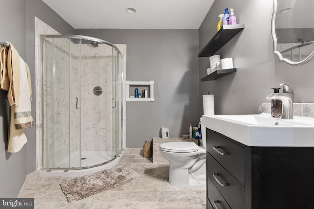 bathroom featuring vanity, toilet, and a shower with shower door