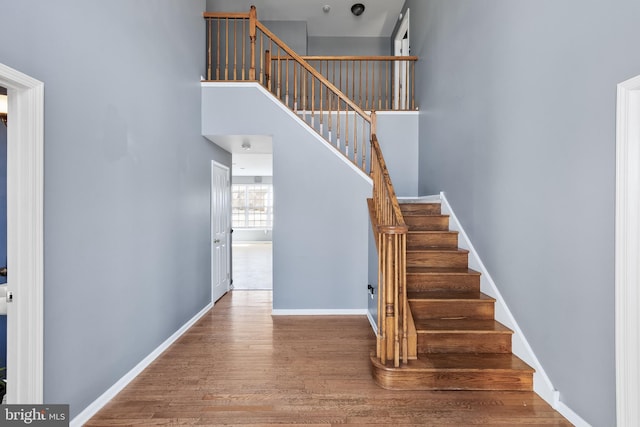 stairway featuring hardwood / wood-style floors and a high ceiling