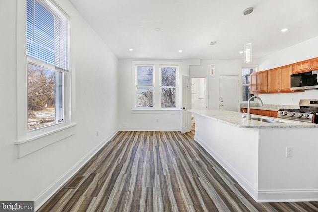 kitchen with sink, plenty of natural light, hanging light fixtures, and appliances with stainless steel finishes