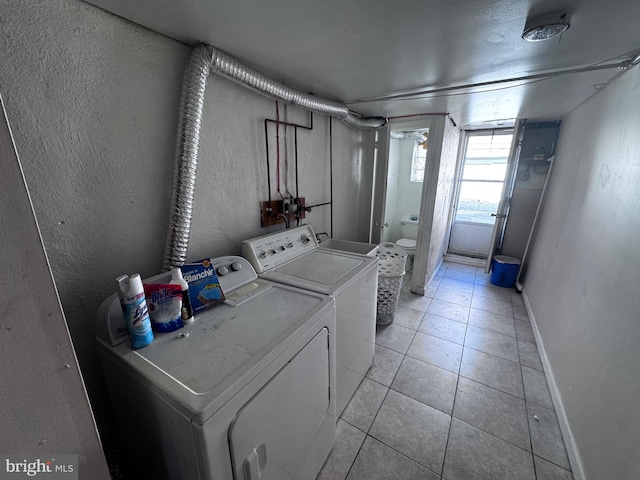 laundry area with washer and dryer and light tile patterned flooring