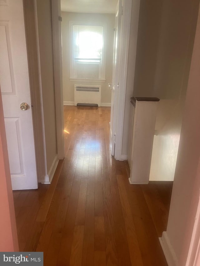 hallway with light wood-type flooring and radiator