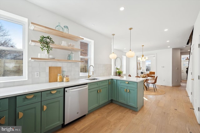 kitchen featuring green cabinets, decorative light fixtures, decorative backsplash, sink, and stainless steel dishwasher