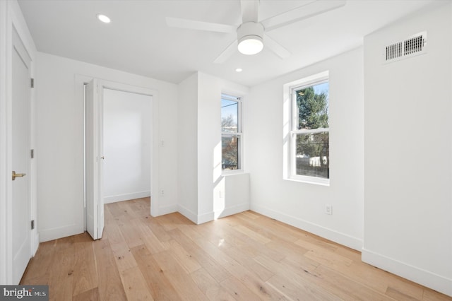 unfurnished bedroom with light wood-type flooring, ceiling fan, and a closet