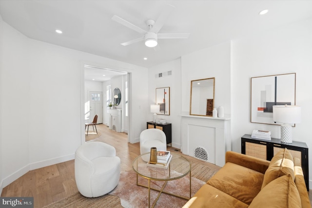 living room featuring ceiling fan and light hardwood / wood-style flooring