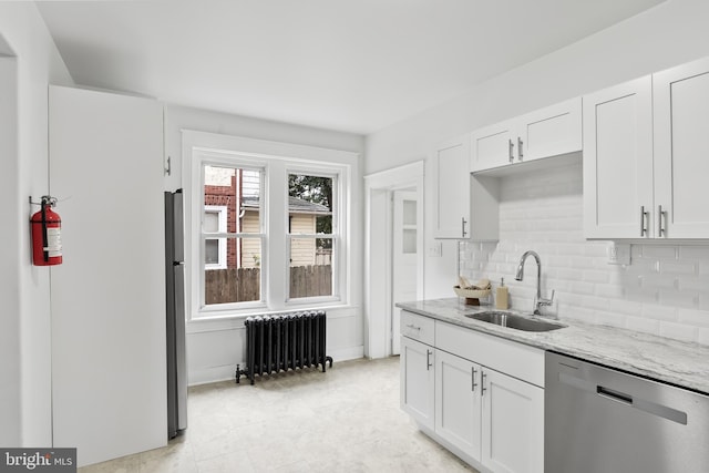 kitchen with white cabinets, appliances with stainless steel finishes, sink, and radiator heating unit