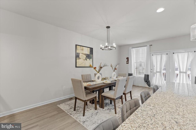 dining room with a notable chandelier and light wood-type flooring