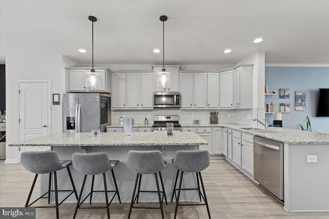 kitchen with stainless steel appliances, hanging light fixtures, light stone counters, and kitchen peninsula