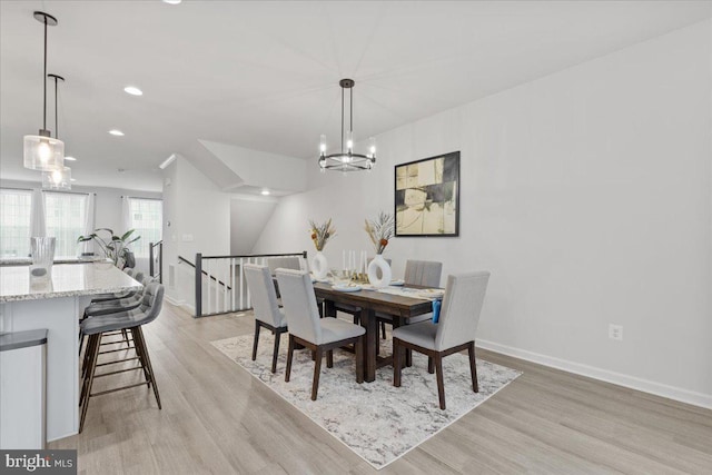 dining room with light hardwood / wood-style floors and a chandelier