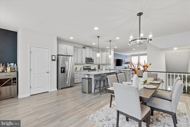 dining space with a chandelier and light hardwood / wood-style flooring