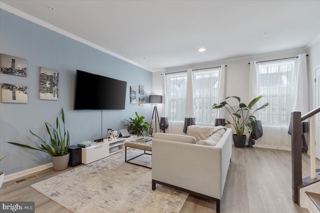 living room with ornamental molding and light hardwood / wood-style flooring