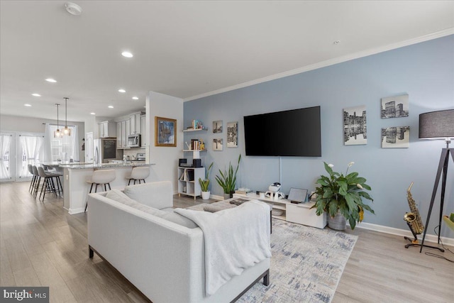 living room with crown molding and light hardwood / wood-style flooring