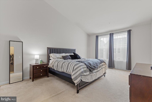 carpeted bedroom with lofted ceiling