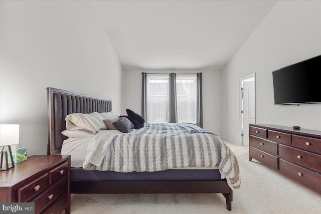 bedroom with lofted ceiling and light colored carpet