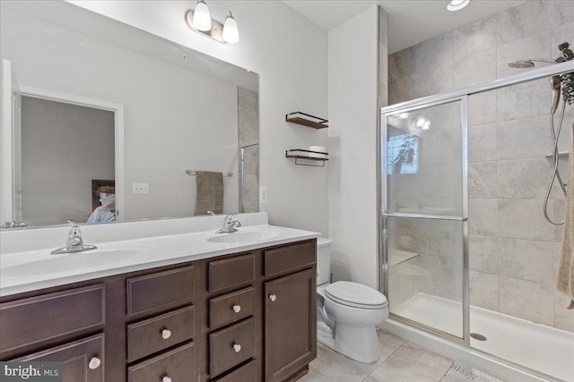 bathroom featuring tile patterned flooring, vanity, a shower with door, and toilet