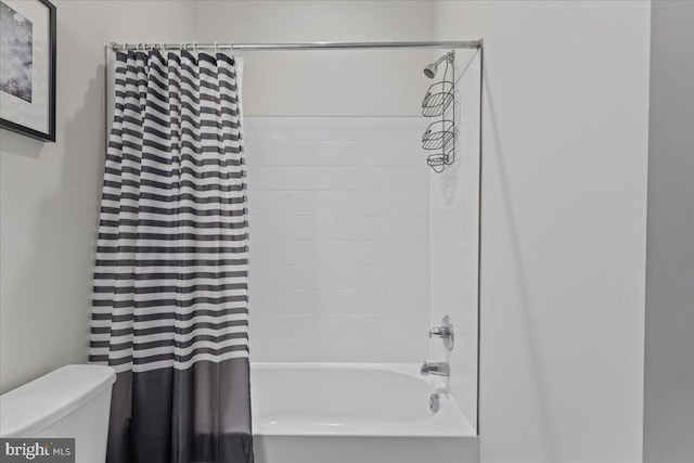 bathroom featuring shower / tub combo and toilet