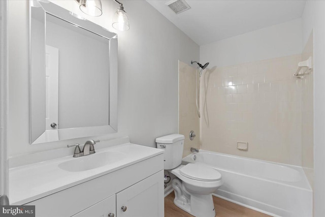 full bathroom featuring vanity, shower / washtub combination, toilet, visible vents, and wood finished floors