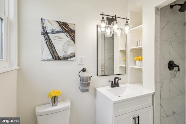 bathroom featuring toilet, vanity, and walk in shower