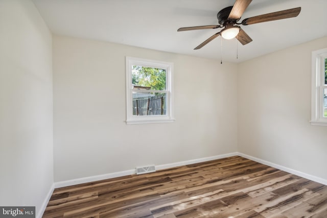 empty room with ceiling fan and dark hardwood / wood-style floors