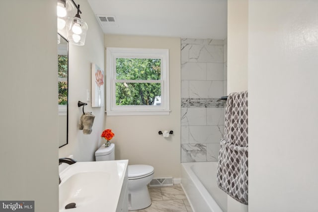 full bathroom featuring toilet, vanity, and tiled shower / bath