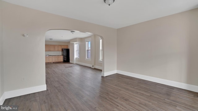 unfurnished living room with dark wood-type flooring