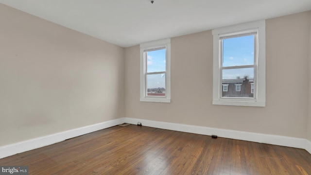 empty room with dark hardwood / wood-style flooring