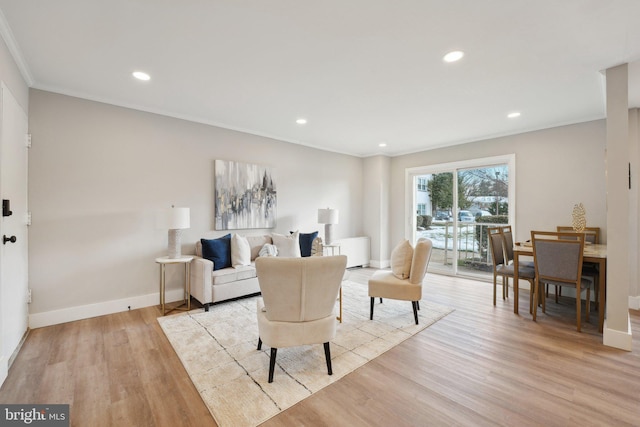 living room featuring light wood-type flooring and ornamental molding