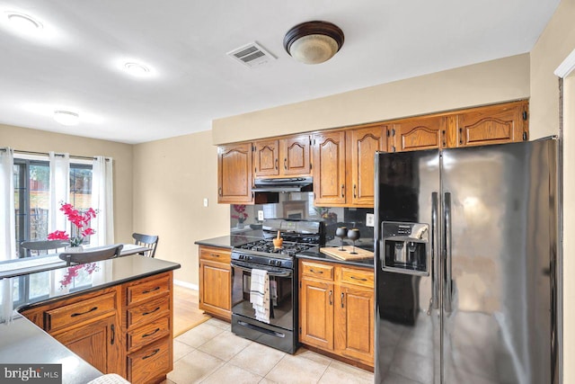 kitchen with light tile patterned floors, black appliances, and tasteful backsplash