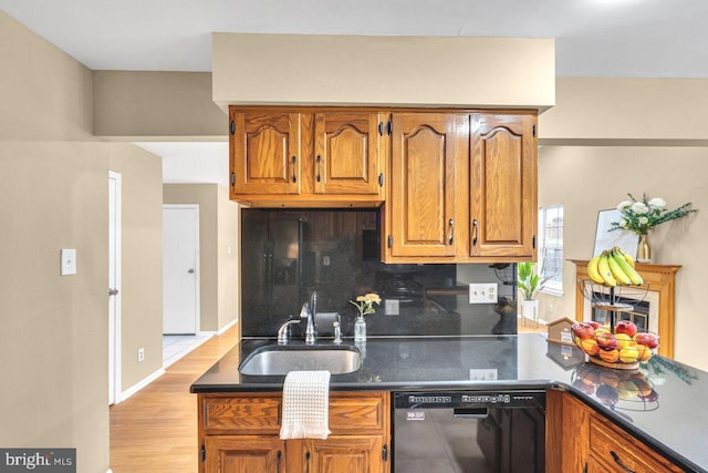 kitchen with light wood-type flooring, dishwasher, decorative backsplash, and sink