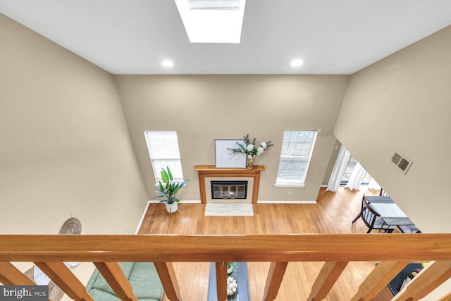 staircase featuring a skylight and hardwood / wood-style flooring