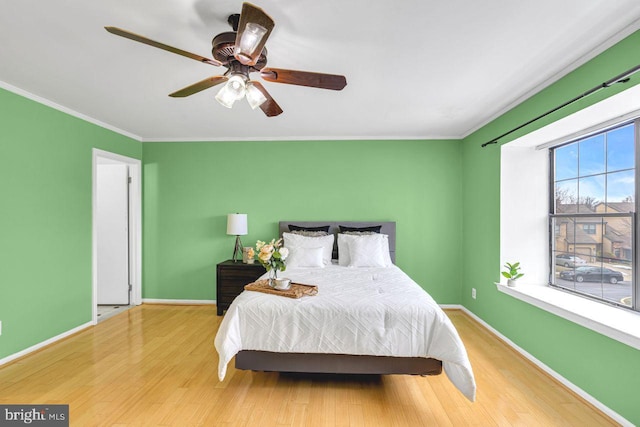 bedroom with ceiling fan, light hardwood / wood-style flooring, and ornamental molding