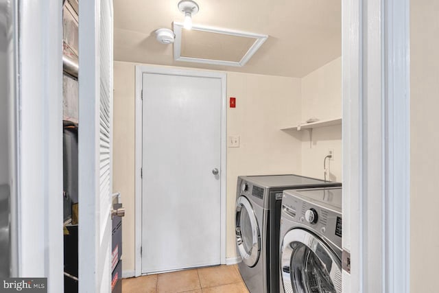 clothes washing area with independent washer and dryer and light tile patterned floors