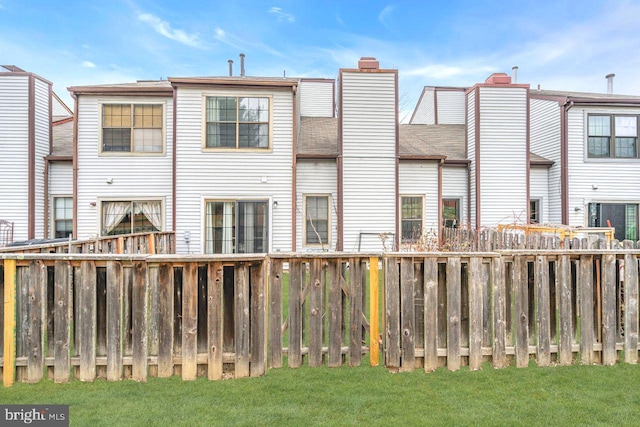 rear view of house featuring a lawn