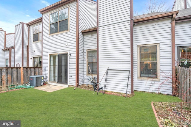 back of house featuring a yard and central AC